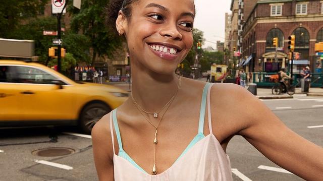 Two women smiling brightly, one on a city street with a yellow taxi, the other enjoying a sunlit moment with water droplets and a rainbow.