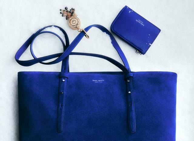 Kate Spade blue leather tote bag with matching wallet and decorative keychain.