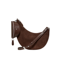 Brown suede crescent-shaped crossbody bag with zipper closure and adjustable strap.