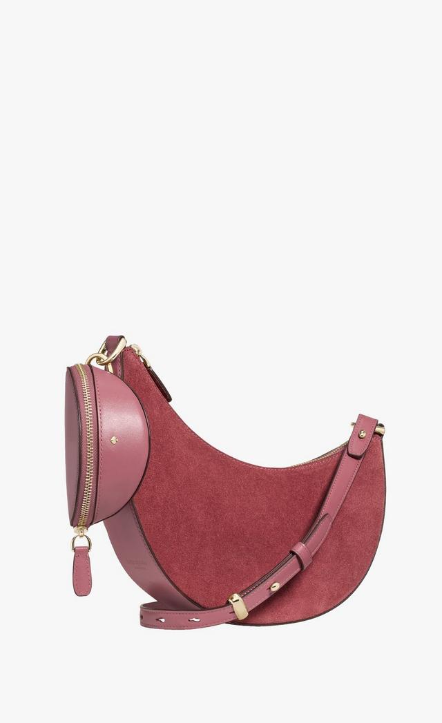 Mauve suede and leather crescent-shaped crossbody bag with adjustable strap and zippered pouch.