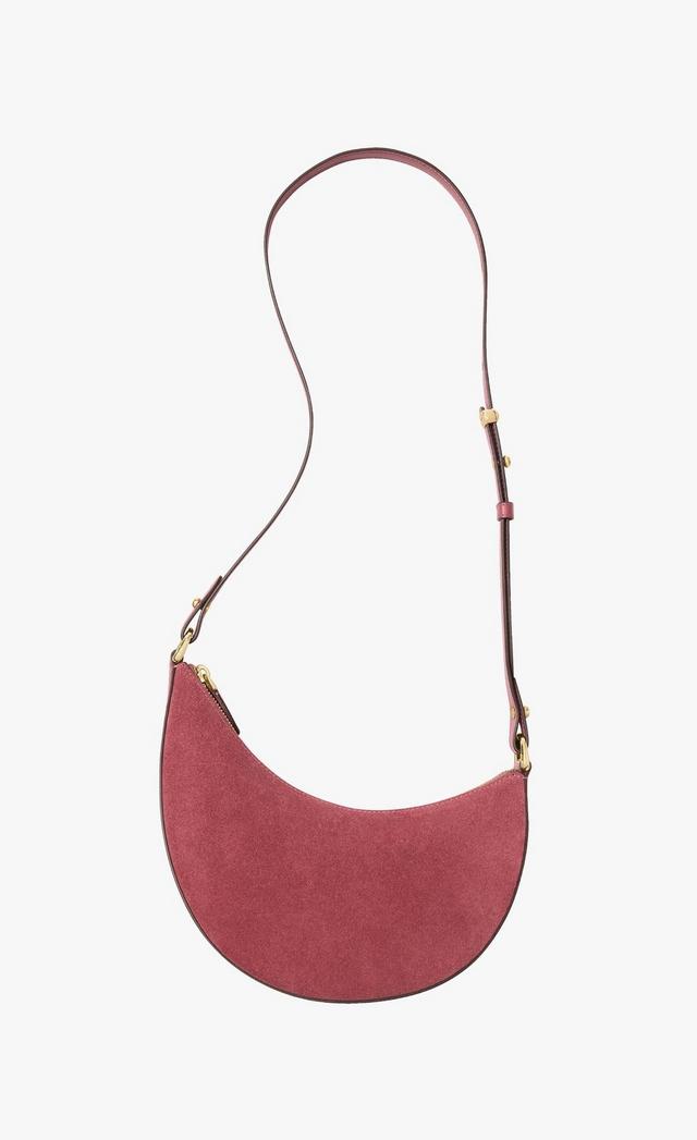 Dusty rose suede crescent-shaped shoulder bag with adjustable leather strap and gold hardware.