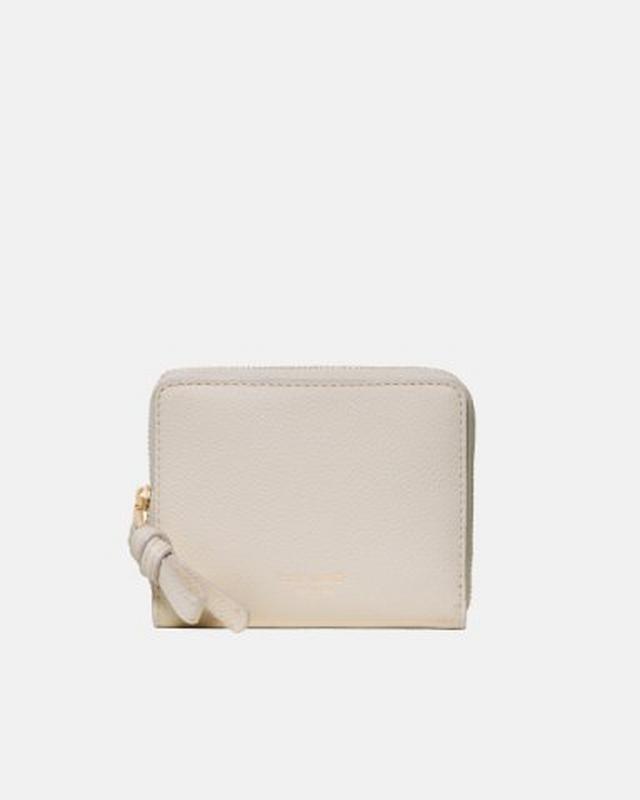 Cream colored leather zip-around wallet with wrist strap and gold-tone hardware.