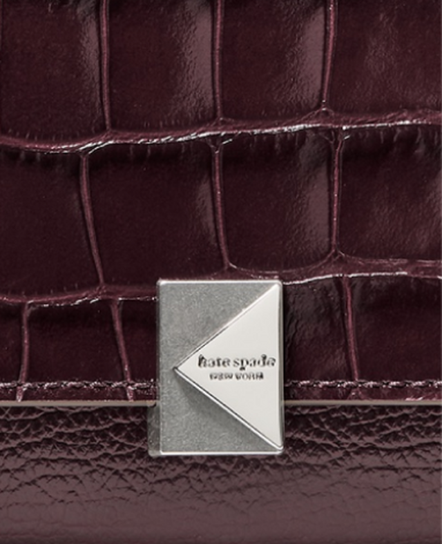 Kate Spade New York burgundy crocodile-embossed leather with silver-tone geometric logo plaque.