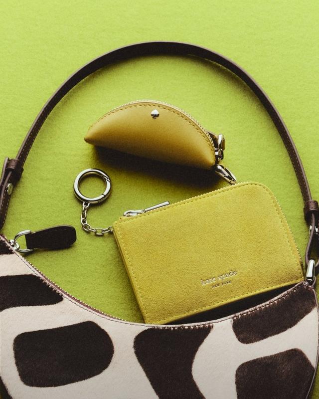 kate spade new york cow print shoulder bag with chartreuse coin purse and mouse-shaped accessory.