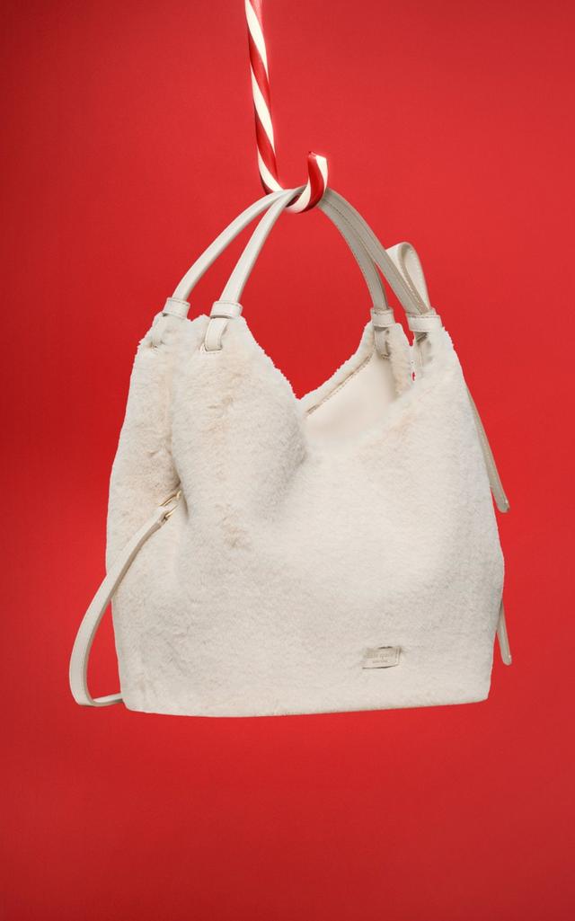 Cream-colored faux fur tote bag with dual handles and detachable shoulder strap.