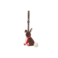 Brown plush bunny toy with red scarf and white tail, attached to a strap for carrying.