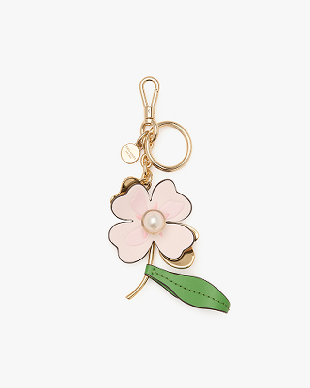 a pink flower keychain with a green leaf on it