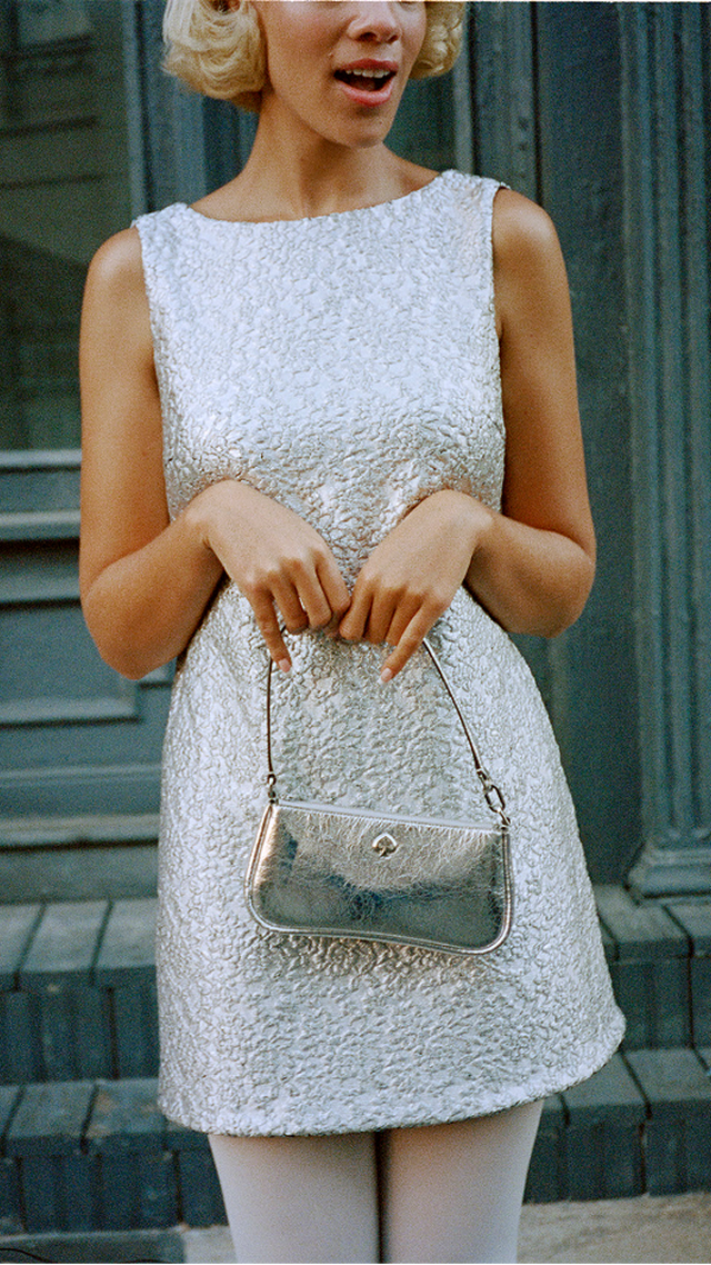 a woman in white dress holding a purse and a purse