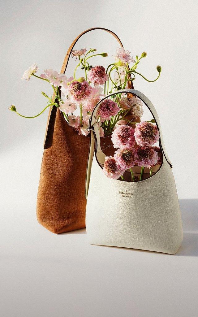 a woman carrying the kate spade outlet kayla wristlet bag