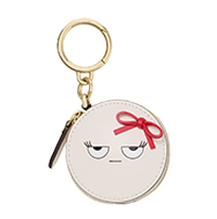 Round coin purse keychain with smiling face design wearing a red bow.