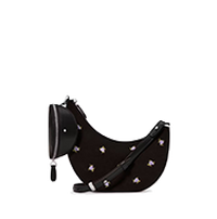 Black crescent-shaped crossbody bag with floral embellishments and adjustable strap.