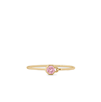 Delicate gold ring with a small pink oval gemstone flanked by tiny clear accent stones.