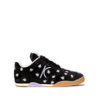 Black sneaker with white polka dots and hook-and-loop straps, featuring a gum sole.